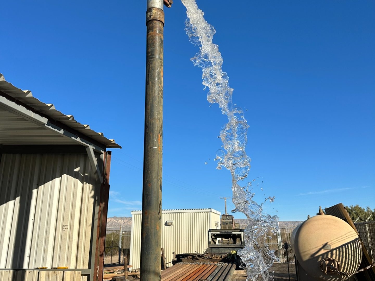 Water gushing from a freshly drilled well on a Southern California property — Roadrunner Well Drilling job site